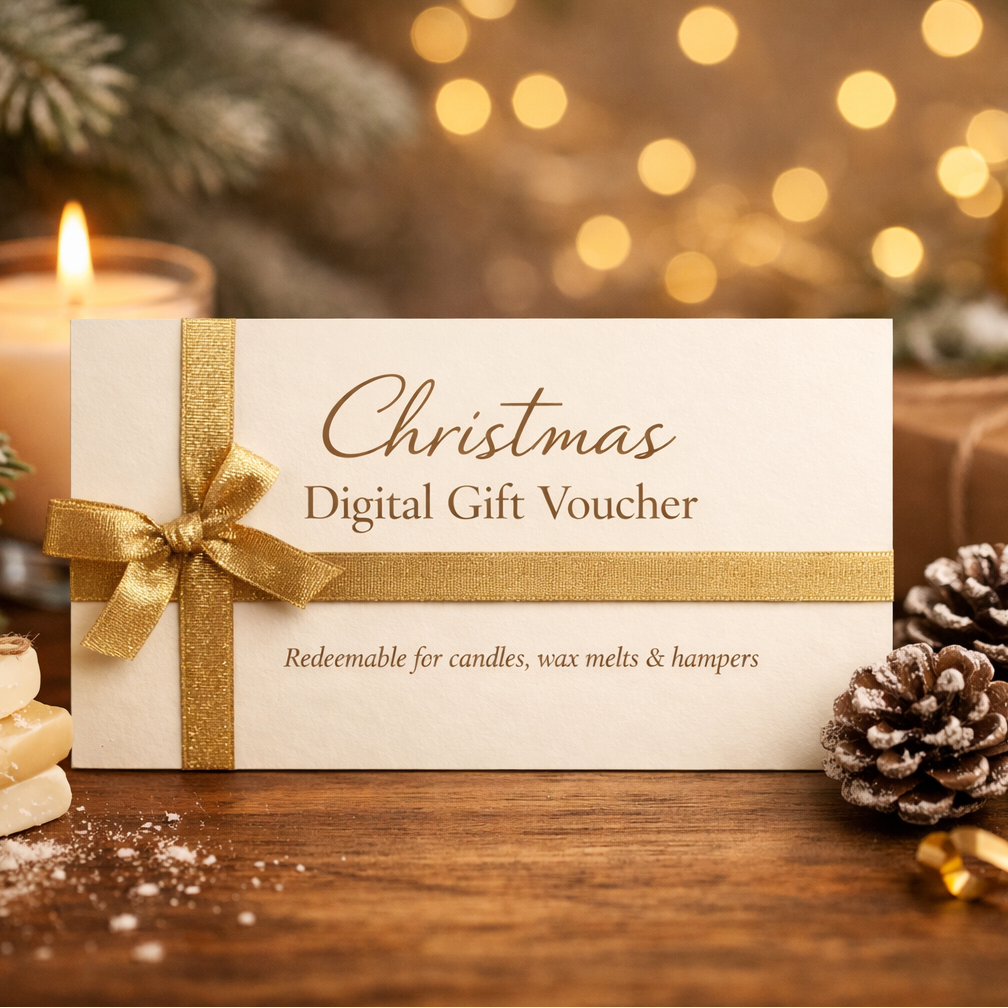 Christmas digital gift voucher with gold ribbon on a wooden surface with candles and pine cones.